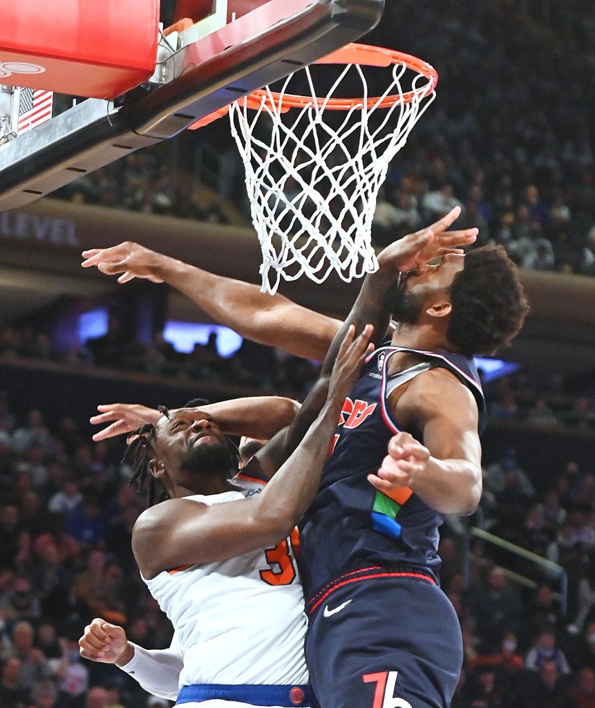 L'attaccante dei Knicks Julius Randle viene fermato dal giocatore dei 76ers Joel Embiid durante la prima metà di una partita domenica 27 febbraio 2022 al Madison Square Garden.