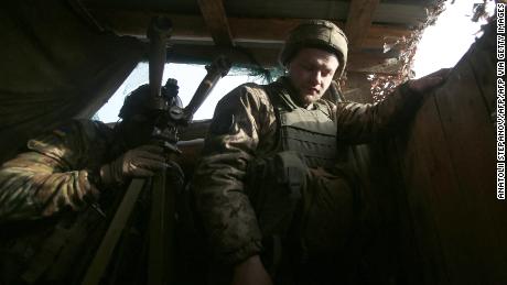 Un soldato ucraino osserva attraverso il binocolo in prima linea con i separatisti sostenuti dalla Russia, vicino a Novologansk, nella regione di Donetsk, il 17 febbraio 2022. 