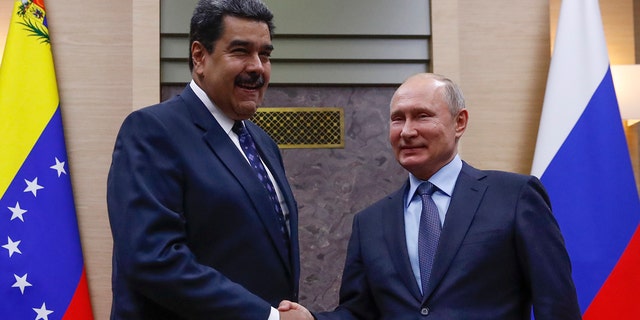 Il presidente russo Vladimir Putin stringe la mano al suo omologo venezuelano Nicolas Maduro