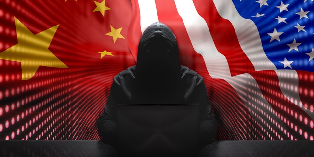 Hacker anonimo davanti al suo computer con sfondo muro a luci rosse Hacker anonimo che indossa una felpa con cappuccio nera con laptop davanti a sfondo icona con sicurezza informatica concetto di flussi binari.