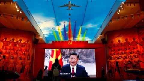 I visitatori si trovano di fronte a uno schermo gigante che mostra un ritratto di Xi Jinping, nel Museo militare della rivoluzione popolare cinese a Pechino.  Sul soffitto viene proiettata l'immagine di un aereo con scie di fumo multicolori