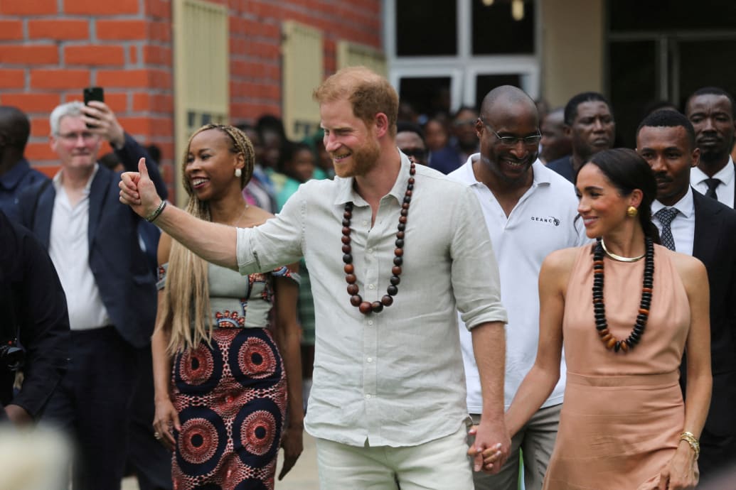 Il principe Harry, duca di Sussex, e sua moglie Meghan, duchessa di Sussex, escono dopo l'incontro con gli studenti alla Lightway Academy di Abuja, Nigeria, 10 maggio 2024.