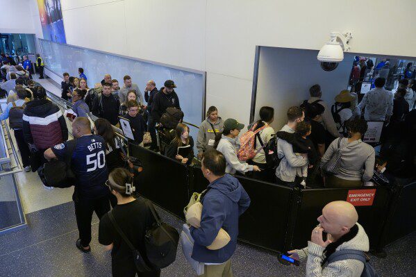 I viaggiatori aspettano al checkpoint della TSA all'aeroporto internazionale di Los Angeles, giovedì 23 maggio 2024, a Los Angeles.  Si prevede che un numero record di americani viaggeranno durante il fine settimana del Memorial Day del 2024 (AP Photo/Ryan Sun)