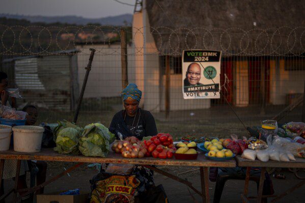 Una donna vende frutta e verdura vicino a un seggio elettorale dove si prevede che l'ex presidente sudafricano Jacob Zuma esprima il suo voto, a KwaZulu-Natal, Sud Africa, Sud Africa, martedì 28 maggio 2024, in previsione delle elezioni generali previste per il 2024 per il 29 maggio. (AP Photo /Emilio Morenatti)